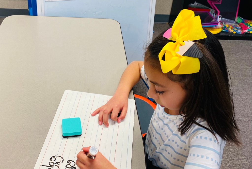 child writing on whiteboard